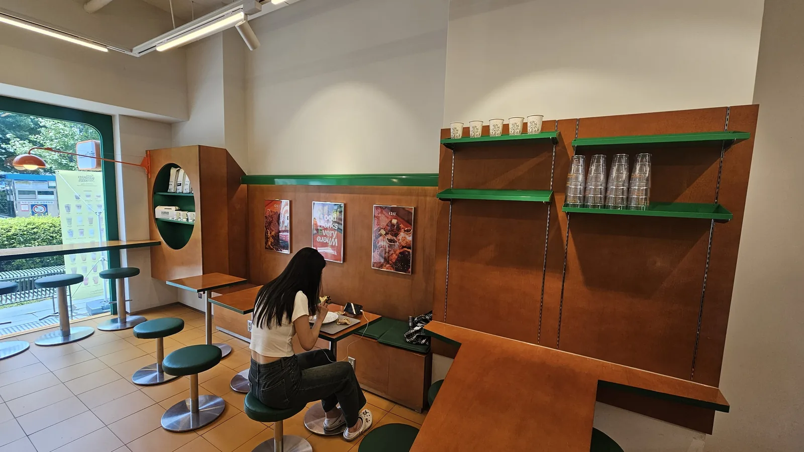Small indoor seating area at Sunsun Coffee Yeouido with wood and green accent decor, solo female customer dining alone