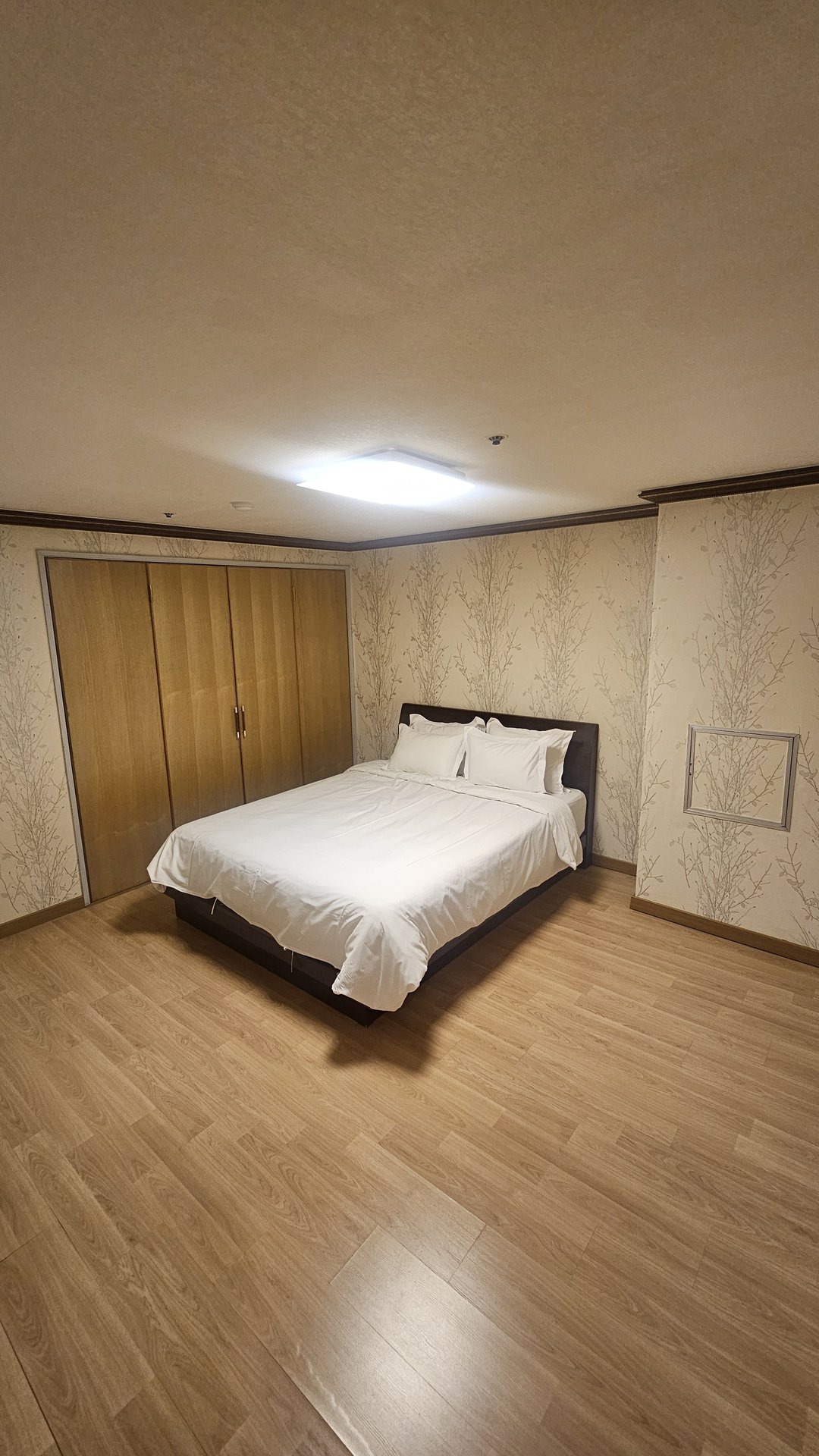 Vivace Resort Royal Suite bedroom interior with branch-pattern wallpaper and wood flooring