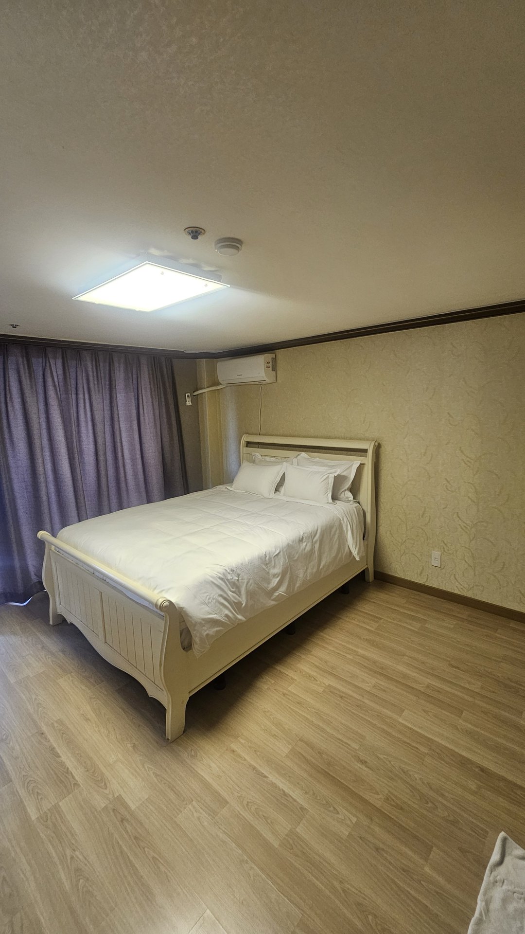 Second bedroom in Vivace Resort Royal Suite with white frame bed and purple carpet