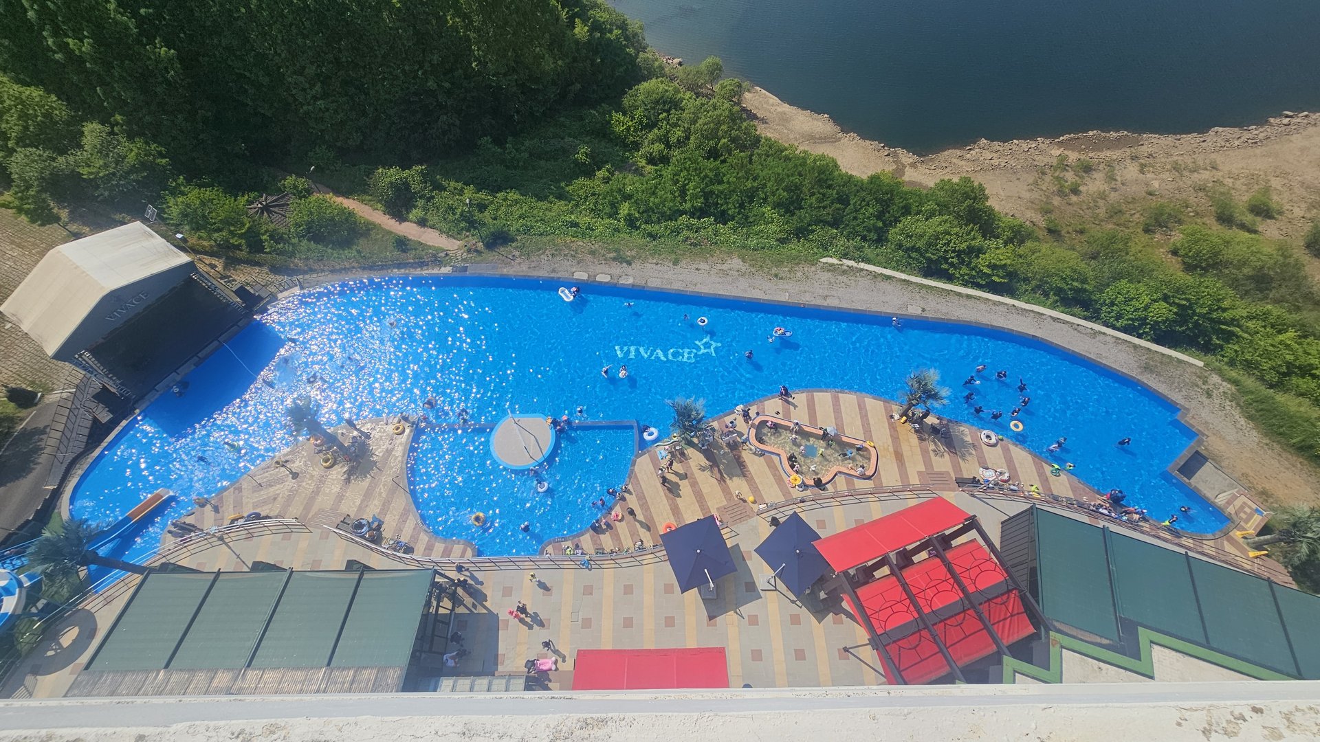 Vivace Resort outdoor pool from above with waterpark area, swimmers, and Seomjin River nearby