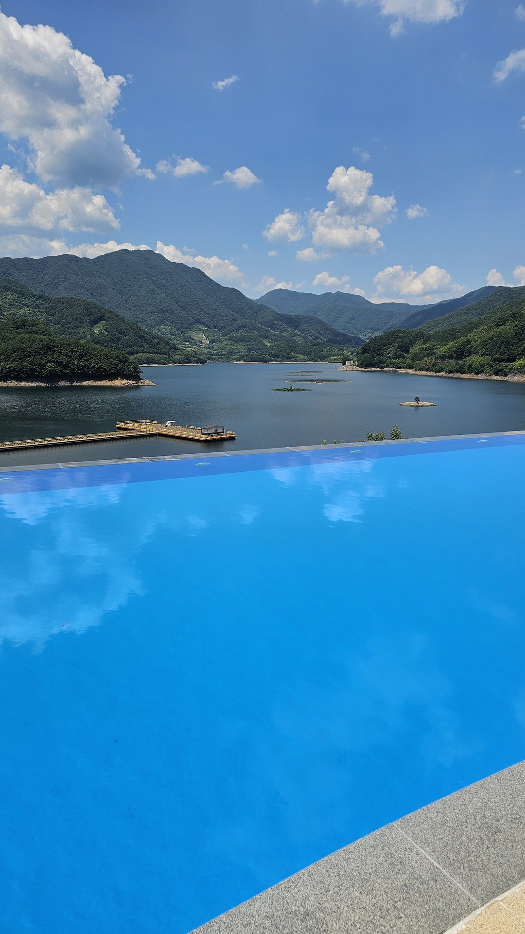Infinity pool edge at Vivace Resort Hadong reflecting river and mountain scenery in daytime