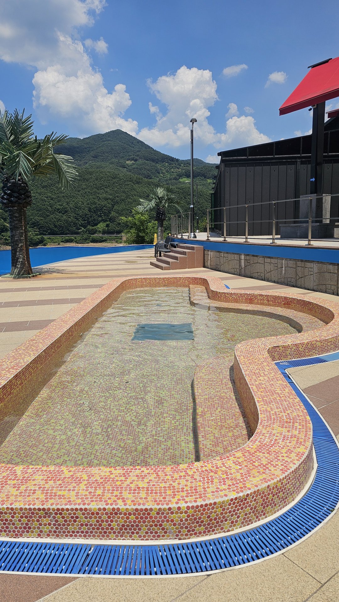 Kids water park area at Vivace Resort Hadong with mosaic tile shallow pool and palm trees