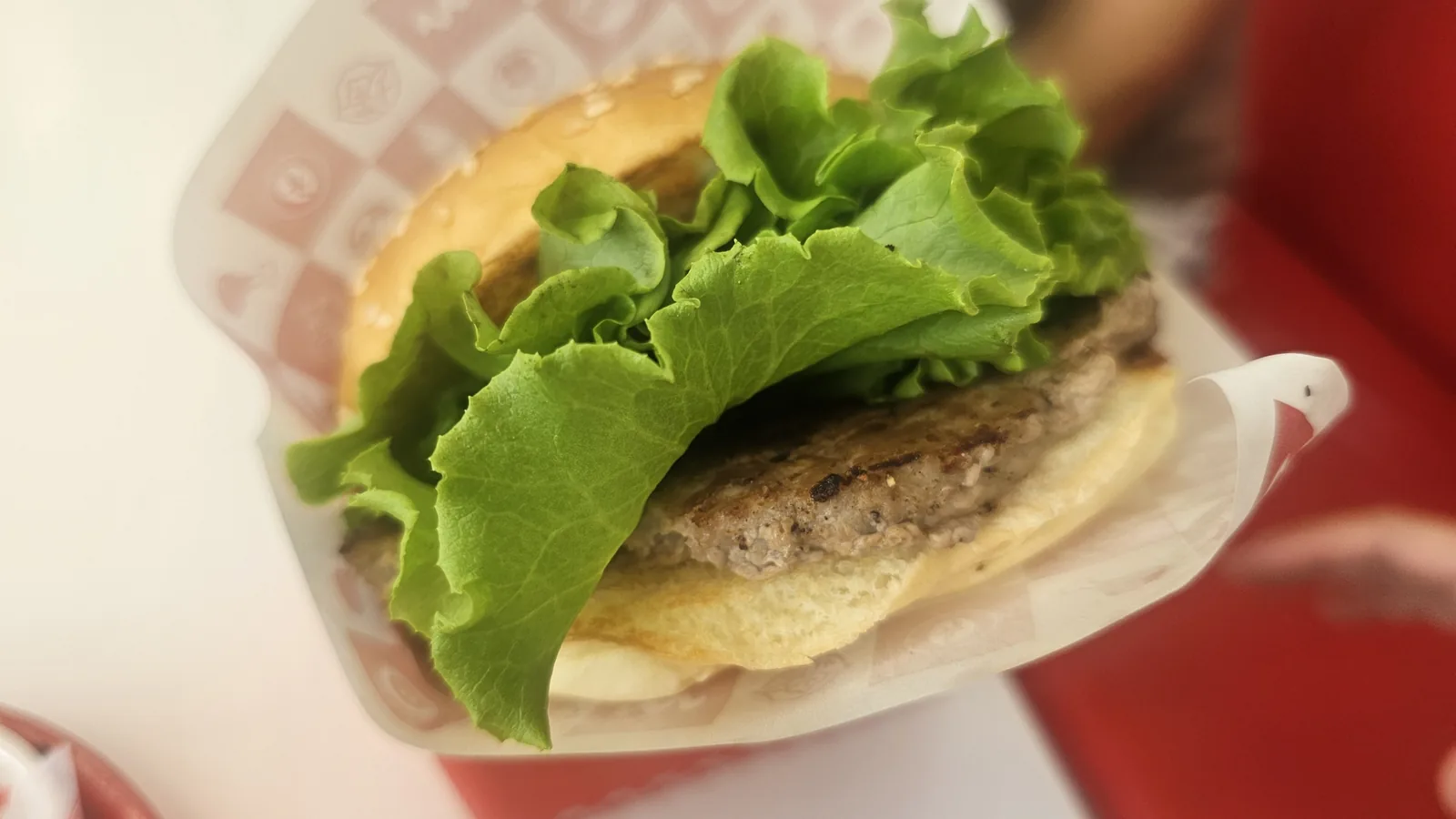 ワット・ザ・バーガー청양店の직화（ジクファ）불고기（プルゴギ）バーガーの断面クローズアップ。直火焼きの牛肉パティとレタスが見える
