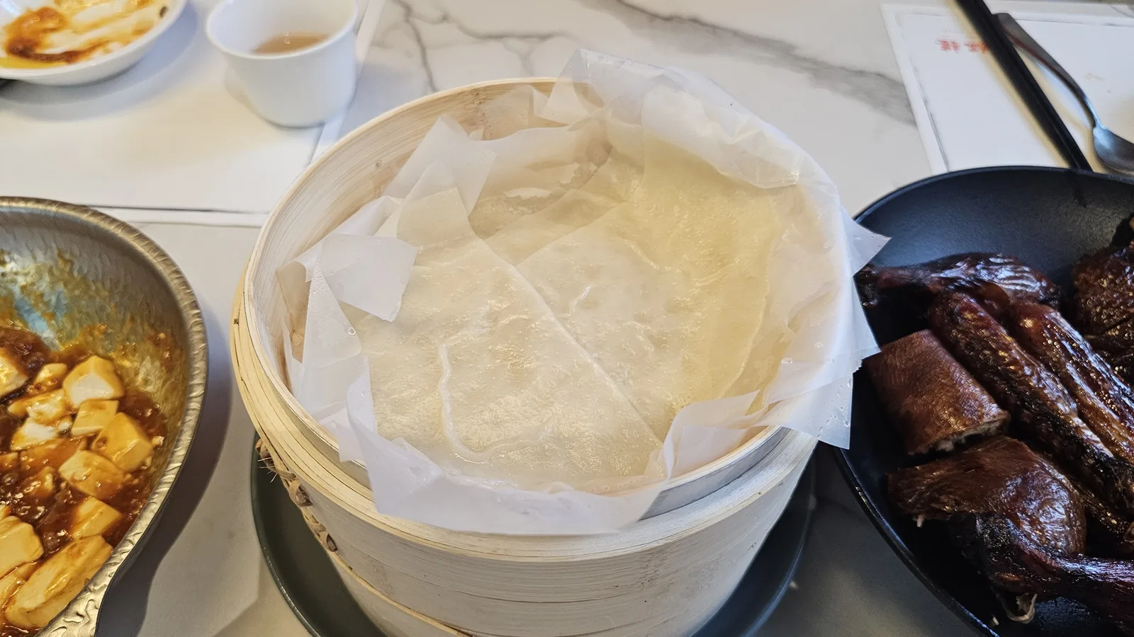 Thin flour crepes (bingpi) in bamboo steamer for Peking duck at Xin Hong Lou