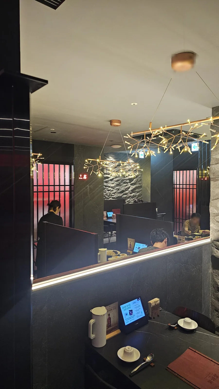Bird's eye view of Xin Hong Lou Yeouido interior from upper level showing red walls and branch chandeliers