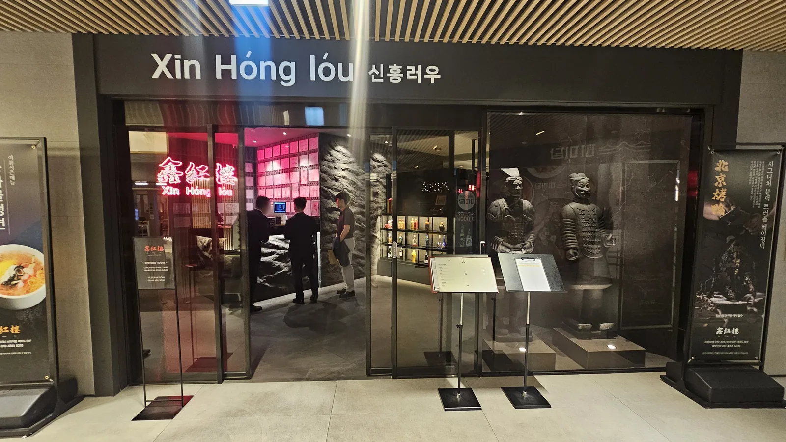 Xin Hong Lou exterior entrance with Xin Hong Lou sign and terracotta warrior sculptures at Yeouido